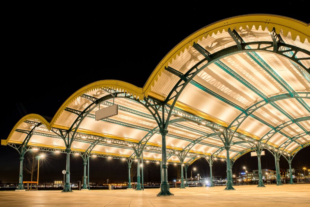 Stunning night view of a lit-up architectural roof with prominent arches in a train station.